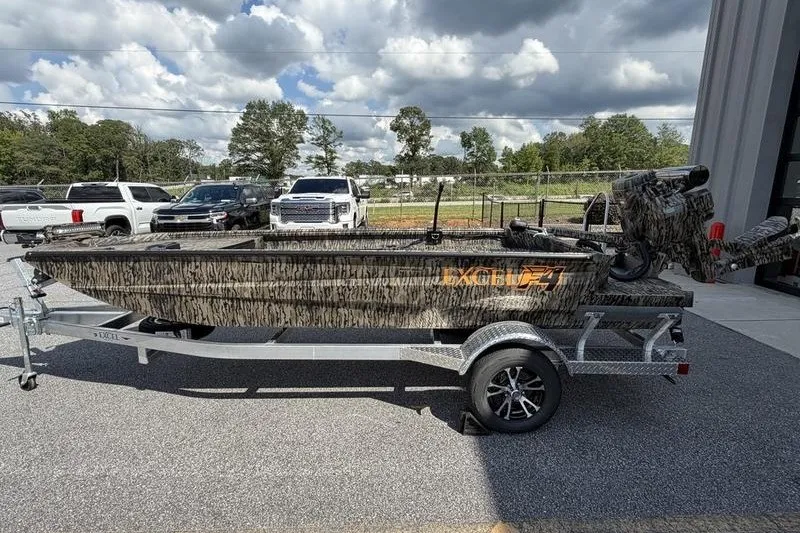 The Image of 2027 Excel 1754 Shallow Water F4 boat on trailer, parked outdoors under cloudy sky. - 0