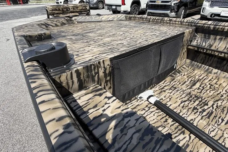 Slide: The Image of 2027 Excel 1754 Shallow Water F4 boat with camouflage pattern, parked outdoors. - 16