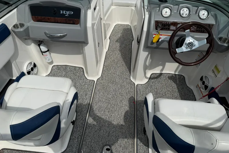 Slide: The Image of Interior of a 2014 Chaparral 21 H2O Sport boat with steering wheel and seating. - 10
