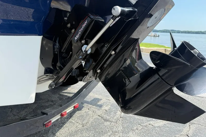 Slide: The Image of Close-up of a 2014 Chaparral 21 H2O Sport boat's MerCruiser outdrive near a lake. - 4