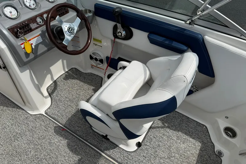Slide: The Image of Interior of a 2014 Chaparral 21 H2O Sport boat, featuring steering wheel and seating. - 11