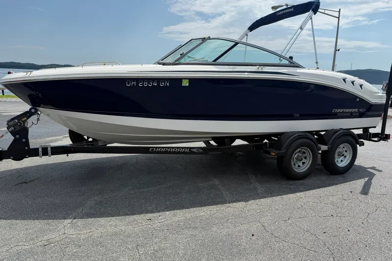 The Image of 2014 Chaparral 21 H2O Sport boat on trailer, parked outdoors under a clear sky. - 1