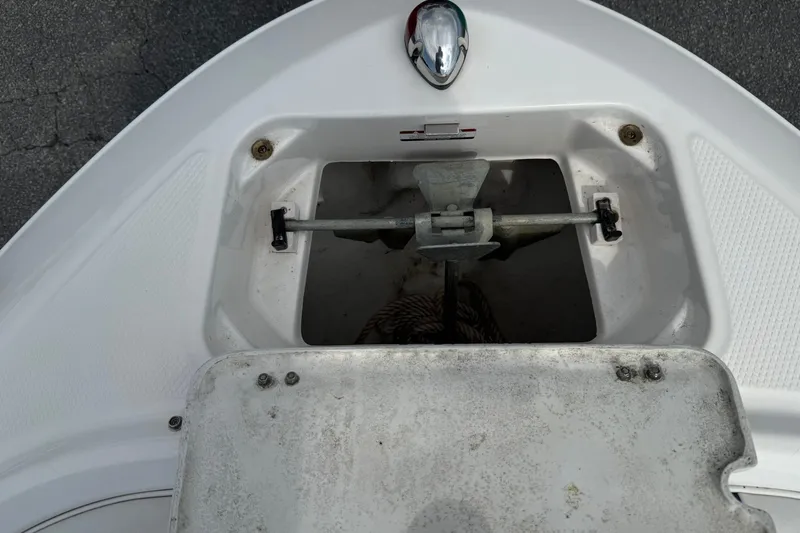 Slide: The Image of Anchor compartment of a 2014 Chaparral 21 H2O Sport boat, featuring a secured anchor. - 23