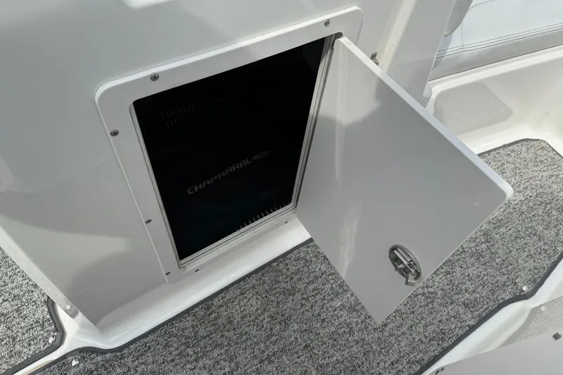 Slide: The Image of Open storage compartment on 2014 Chaparral 21 H2O Sport boat, featuring carpeted flooring. - 20