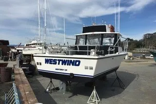 Slide: The Image of 2002 Island Hopper Forward Cabin boat named "Westwind" docked at a marina. - 3