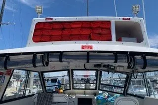 Slide: The Image of 2002 Island Hopper Forward Cabin boat with visible life jackets and marina background. - 15