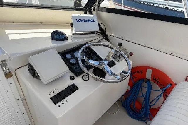 Slide: The Image of 2002 Island Hopper Forward Cabin boat helm with steering wheel, Lowrance device, and life preserver. - 7