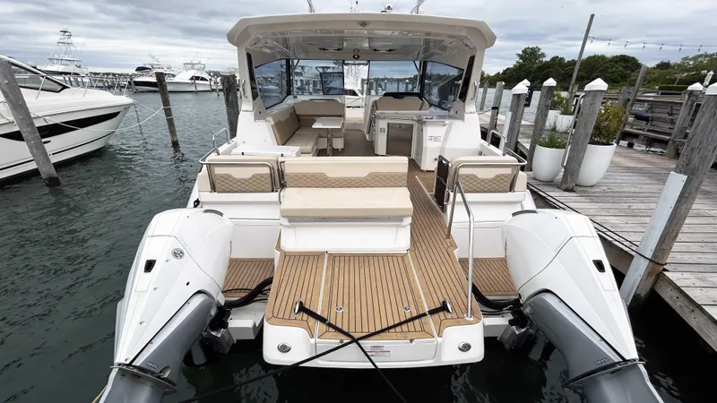 Slide: The Image of Aquila 36 Sport 2021 boat docked, featuring spacious seating and dual outboard engines. - 4