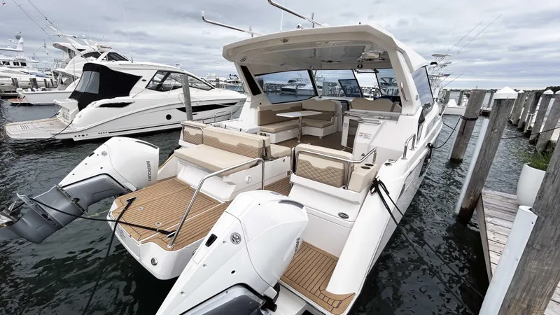 Slide: The Image of Aquila 36 Sport 2021 boat docked, featuring spacious seating and dual outboard engines. - 3