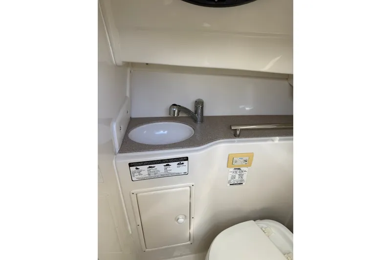 Slide: The Image of 2014 Sailfish 270 WAC boat interior with sink and storage compartment. - 16