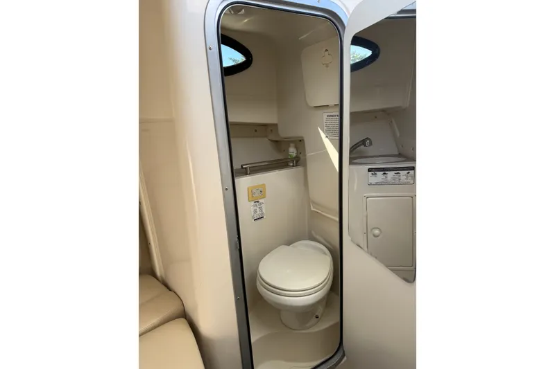 Slide: The Image of 2014 Sailfish 270 WAC boat interior bathroom with toilet and sink. - 15