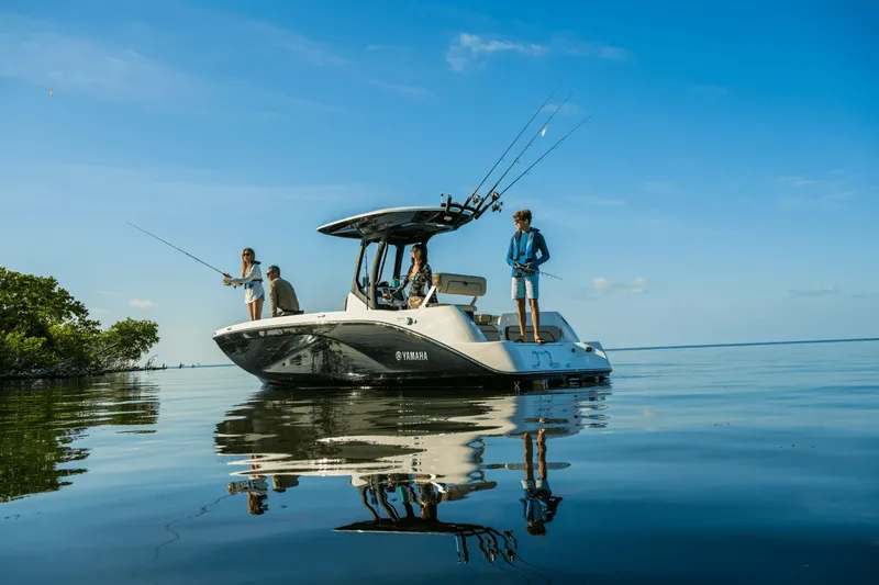 Slide: The Image of Four people fishing on a Yamaha 222 FSH Sport E boat on calm water. - 6