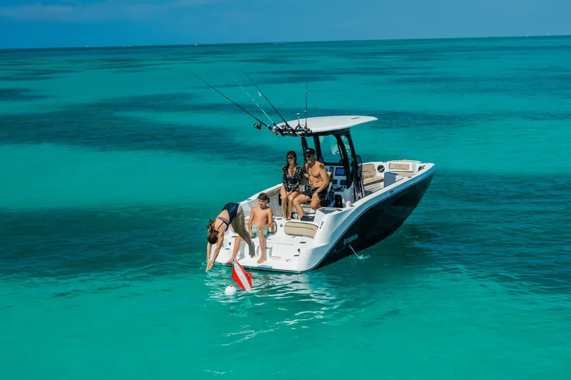 Slide: The Image of A group of people enjoying a day on a Yamaha 222 FSH Sport E boat in clear waters. - 9