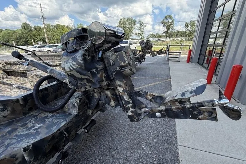 Slide: The Image of 2027 Excel 1754 Shallow Water F4 boat with camouflage design, parked outside a building. - 8