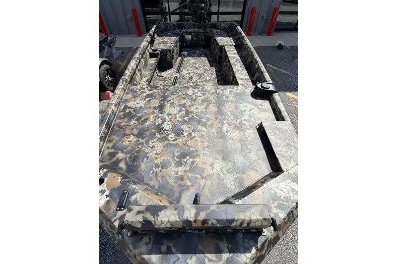 Slide: The Image of 2027 Excel 1754 Shallow Water F4 boat with camouflage design, parked outdoors. - 24