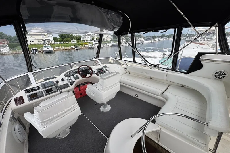 Slide: The Image of 1998 Sea Ray 420 Aft Cabin yacht interior with helm, seating, and marina view. - 5