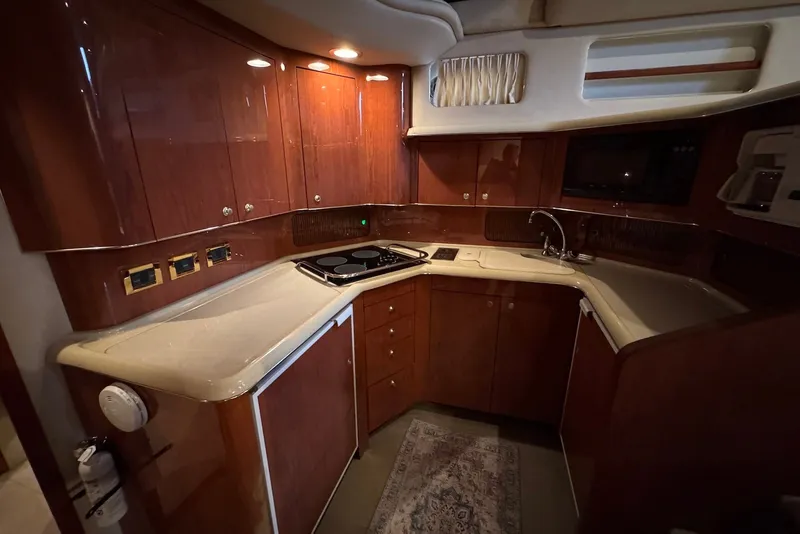 Slide: The Image of Luxurious kitchen interior of 1998 Sea Ray 420 Aft Cabin yacht with wooden cabinetry. - 16
