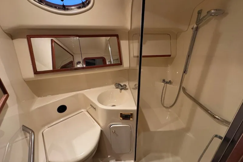 Slide: The Image of 1998 Sea Ray 420 Aft Cabin bathroom with shower, sink, and mirror. - 18