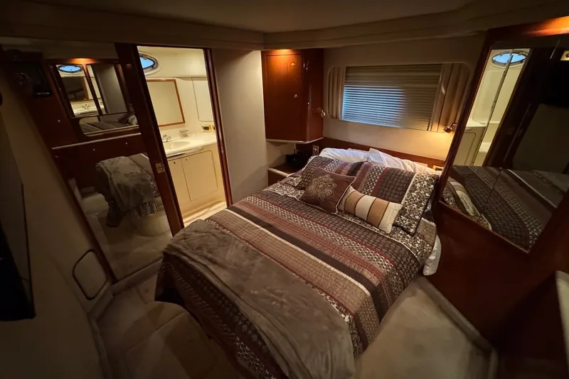 Slide: The Image of Luxurious 1998 Sea Ray 420 Aft Cabin bedroom with elegant bedding and ensuite bathroom. - 21