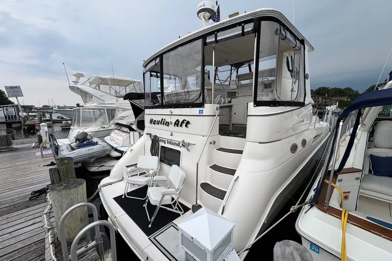 Slide: The Image of 1998 Sea Ray 420 Aft Cabin yacht docked, featuring spacious aft deck and elegant design. - 2
