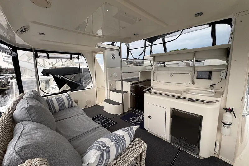 Slide: The Image of 1998 Sea Ray 420 Aft Cabin interior with cozy seating and kitchenette. - 3