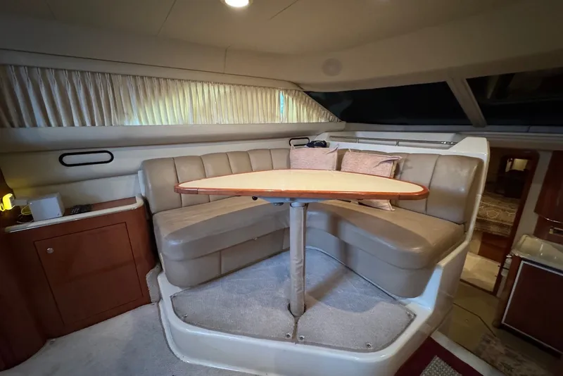 Slide: The Image of Interior of 1998 Sea Ray 420 Aft Cabin with cozy seating and table. - 14