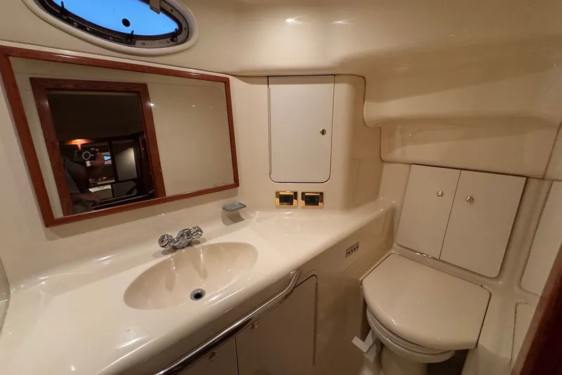 Slide: The Image of 1998 Sea Ray 420 Aft Cabin bathroom with sink, mirror, and toilet. - 22