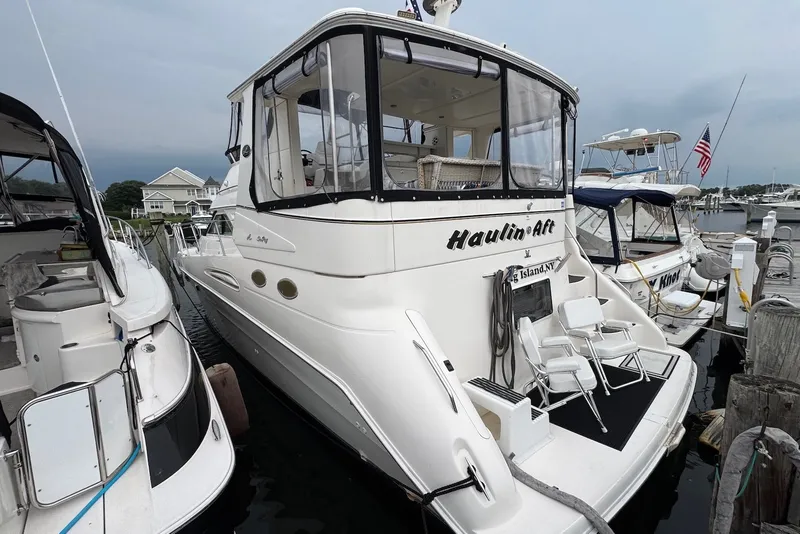 The Image of 1998 Sea Ray 420 Aft Cabin yacht docked at marina, featuring spacious aft deck. - 1