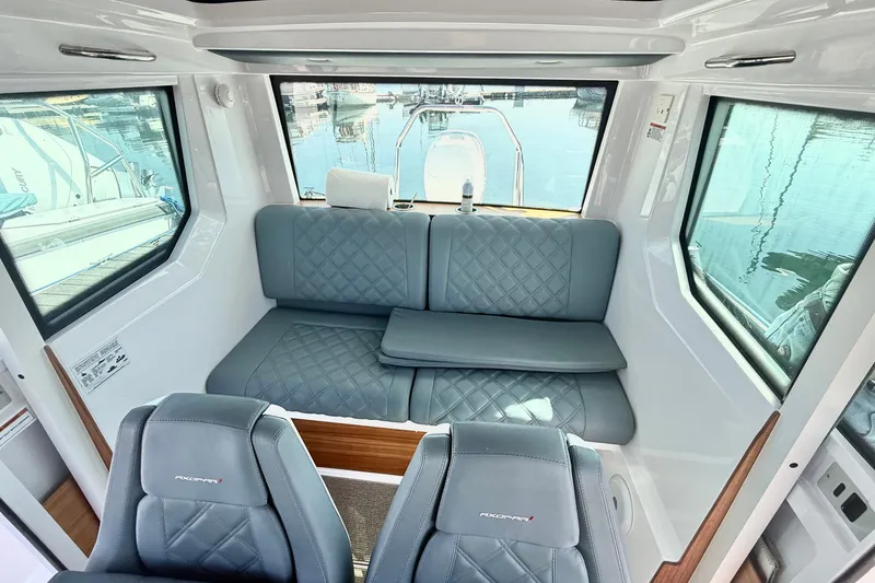 Slide: The Image of Interior of 2022 Axopar 28 Cabin with quilted seating and panoramic windows. - 24