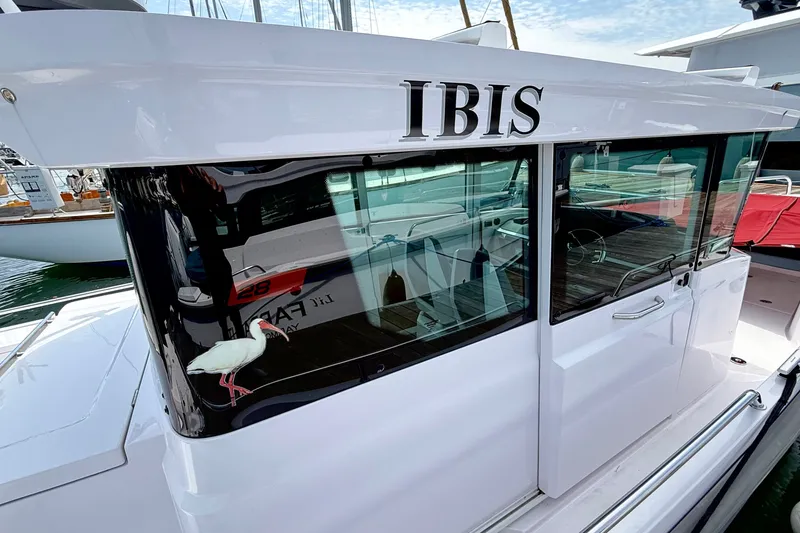 Slide: The Image of 2022 Axopar 28 Cabin boat named "IBIS" docked, featuring sleek design and reflective windows. - 4