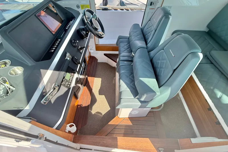 Slide: The Image of Interior of 2022 Axopar 28 Cabin boat with modern dashboard and seating. - 18