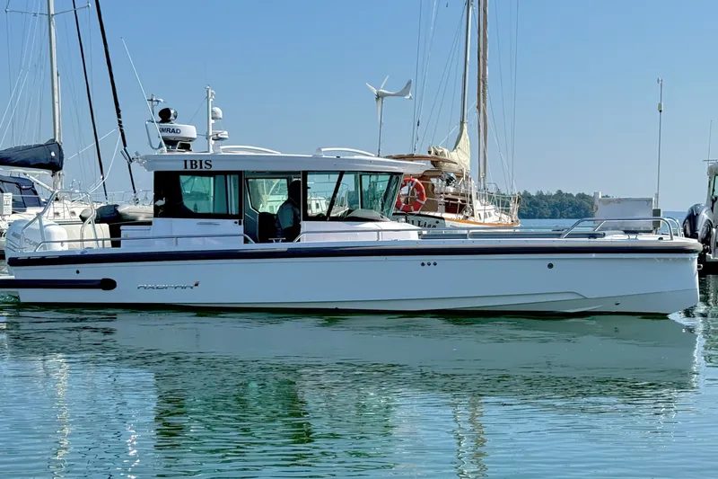 The Image of 2022 Axopar 28 Cabin boat docked in a marina, featuring sleek design and modern amenities. - 0