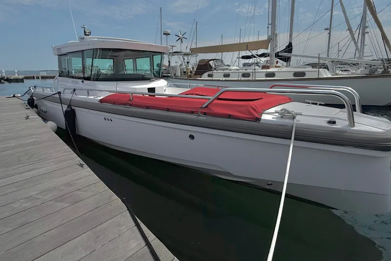 Slide: The Image of 2022 Axopar 28 Cabin boat docked at marina with red cover. - 40