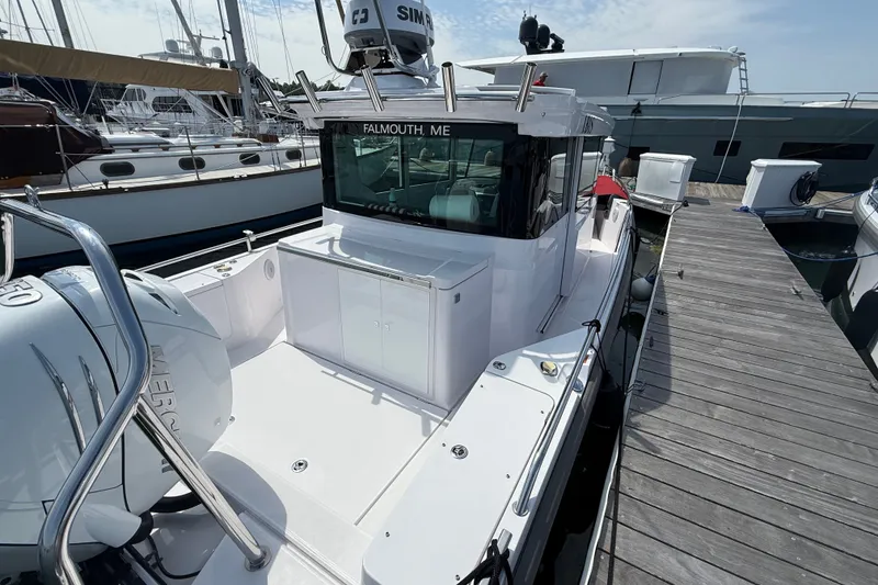 Slide: The Image of 2022 Axopar 28 Cabin boat docked, featuring sleek design and modern equipment. - 9