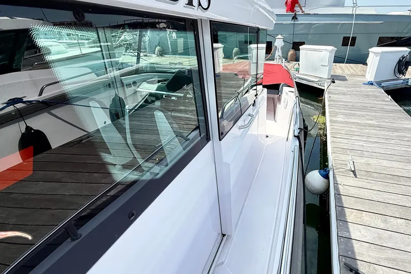 Slide: The Image of 2022 Axopar 28 Cabin boat docked at marina, showcasing sleek design and modern features. - 16