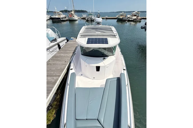 Slide: The Image of 2022 Axopar 28 Cabin boat docked, featuring sleek design and solar panel on roof. - 31