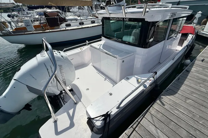 Slide: The Image of 2022 Axopar 28 Cabin boat docked, featuring a Mercury engine and sleek design. - 6