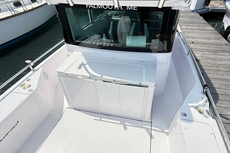 Slide: The Image of 2022 Axopar 28 Cabin boat docked, featuring sleek white design and spacious deck area. - 12