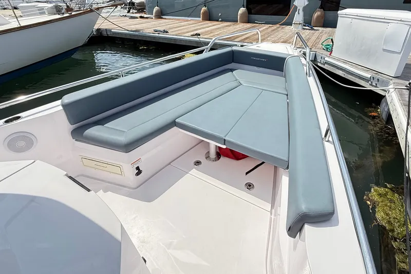 Slide: The Image of 2022 Axopar 28 Cabin boat with sleek seating and modern design at dock. - 28
