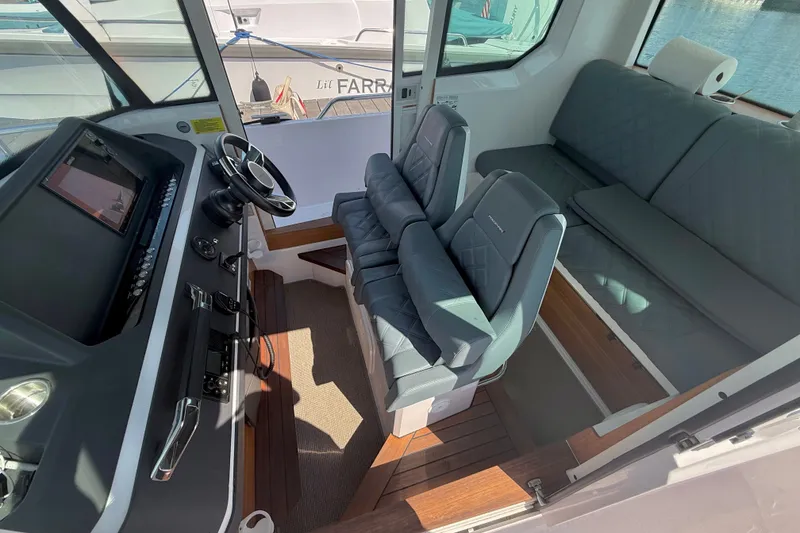 Slide: The Image of Interior of 2022 Axopar 28 Cabin boat with modern seating and steering console. - 17