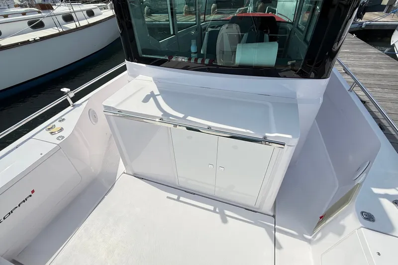 Slide: The Image of 2022 Axopar 28 Cabin boat deck with storage compartment and sleek design. - 13
