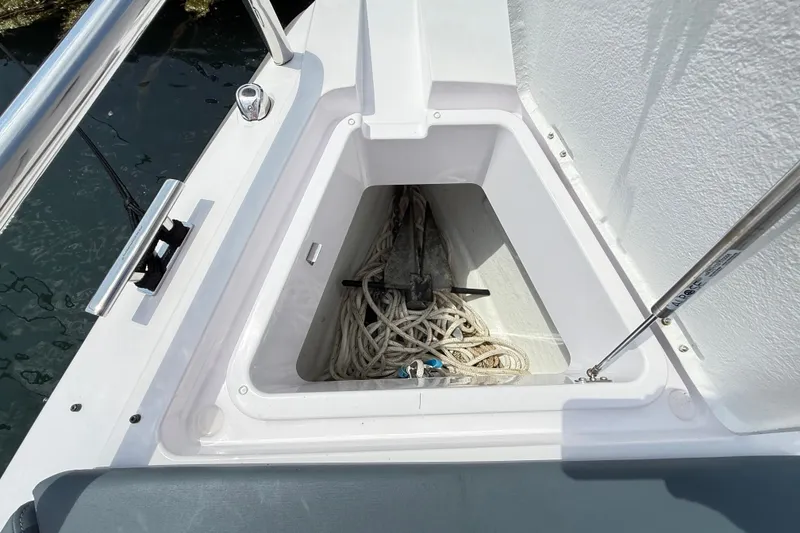 Slide: The Image of Anchor storage compartment on 2022 Axopar 28 Cabin boat, featuring ropes and anchor. - 30