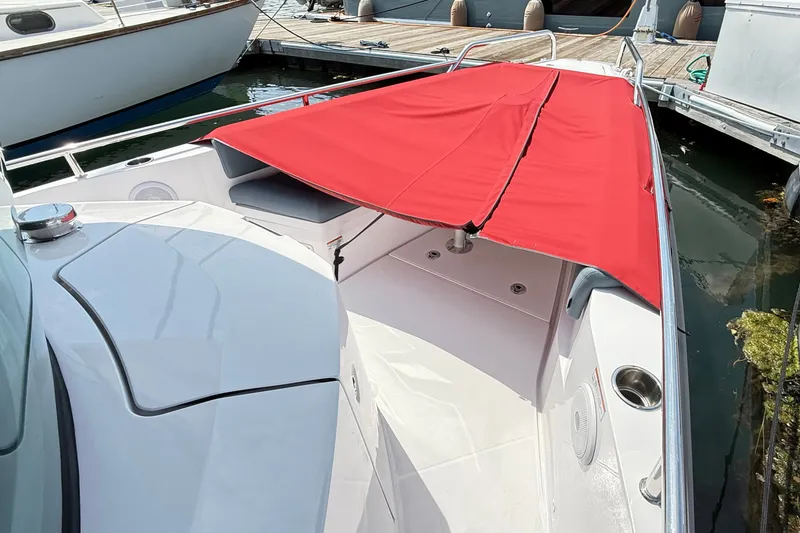Slide: The Image of 2022 Axopar 28 Cabin boat with red canopy docked at marina. - 27