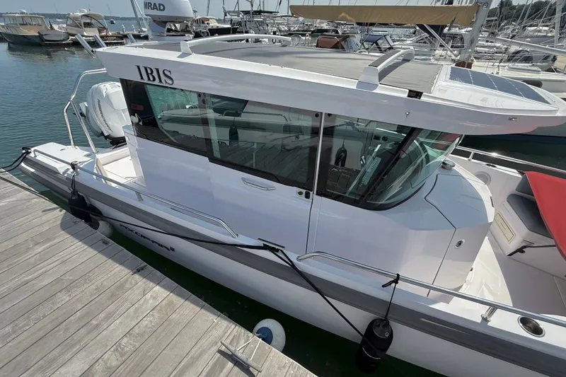 Slide: The Image of 2022 Axopar 28 Cabin boat docked at marina, side view. - 3