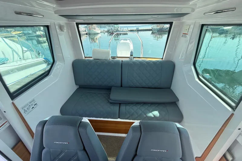 Slide: The Image of Interior of 2022 Axopar 28 Cabin boat with gray seating and large windows. - 25