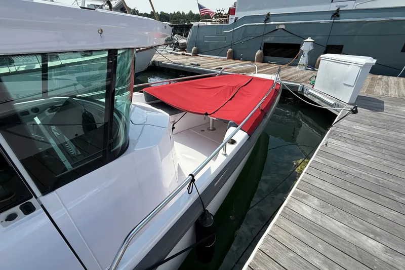 Slide: The Image of 2022 Axopar 28 Cabin boat docked with red cover, side view. - 5