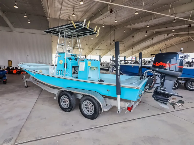 Slide: The Image of A blue boat on a trailer in a large indoor space. It features an outboard motor and elevated helm. - 5