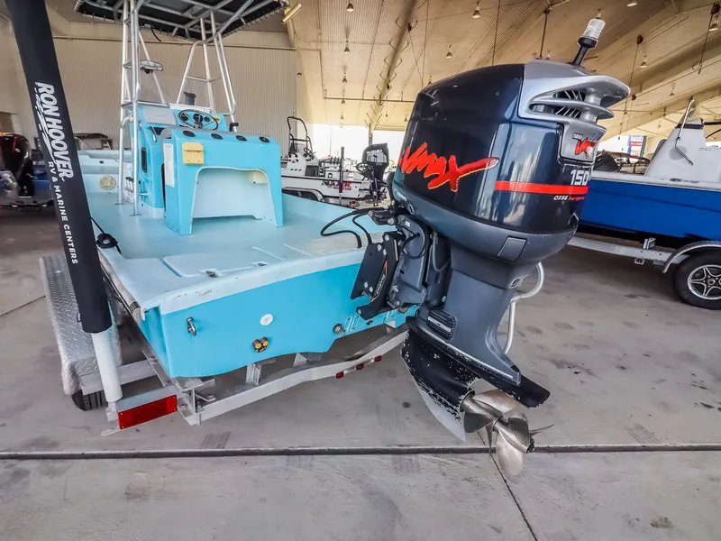 Slide: The Image of A blue boat with a large outboard motor is in a warehouse. - 24