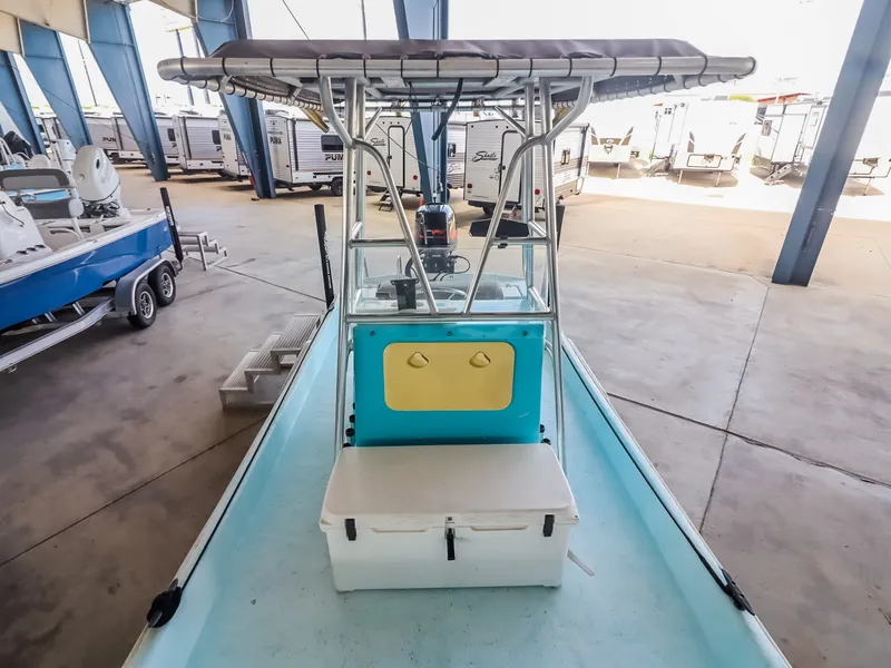 Slide: The Image of An open-deck boat with a T-top, surrounded by trailers in a storage facility. - 12