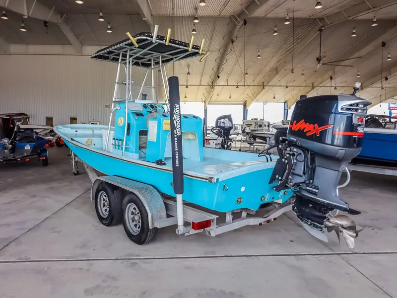Slide: The Image of A blue boat with an outboard motor sits on a trailer in a warehouse. - 6
